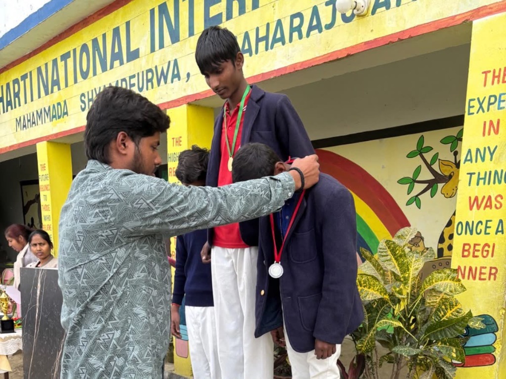 Prize winner receiving sports medal from school educator