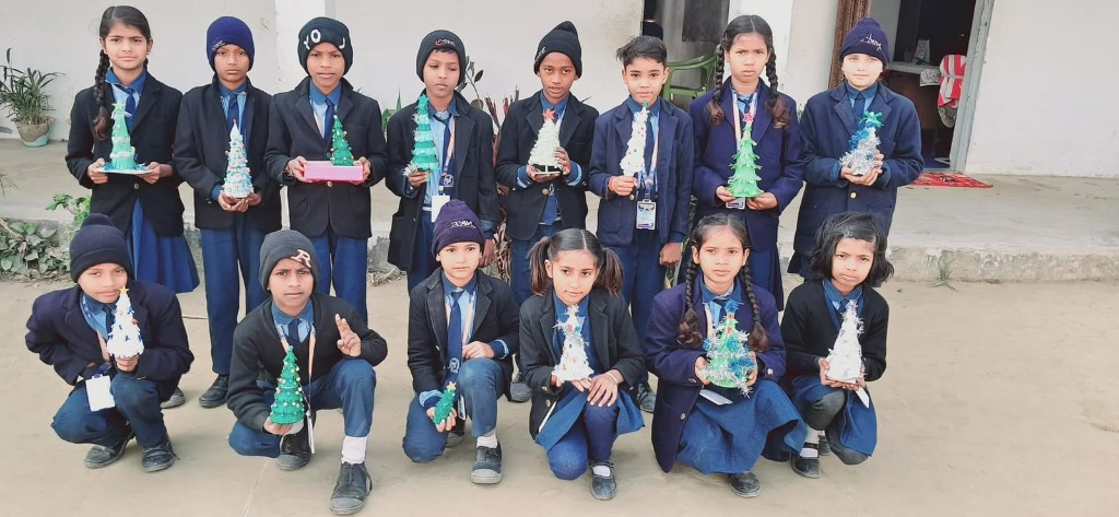 Students posing with handmade paper Christmas trees