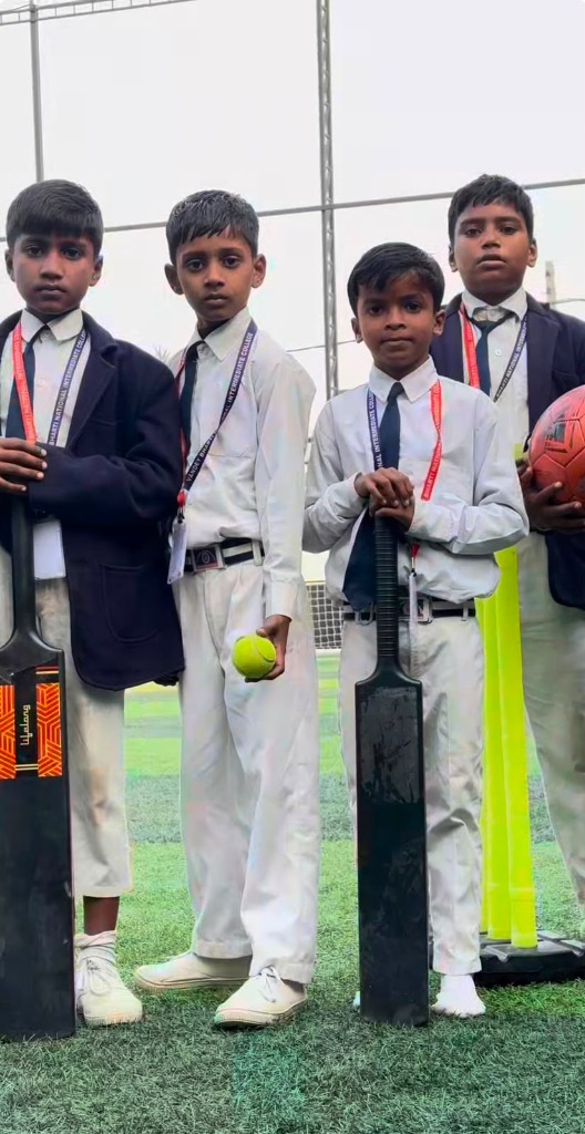 Close-up of boys holding cricket bats and ball