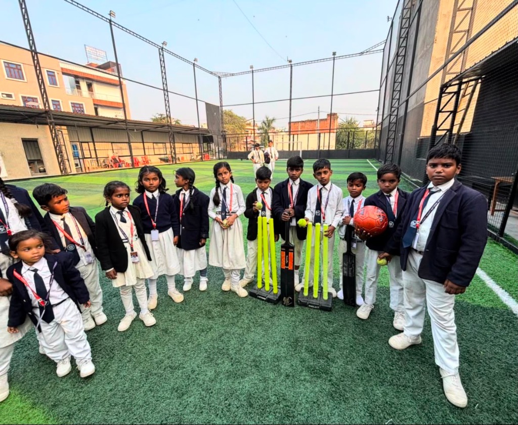 Students posing on artificial turf cricket field with bats and wickets