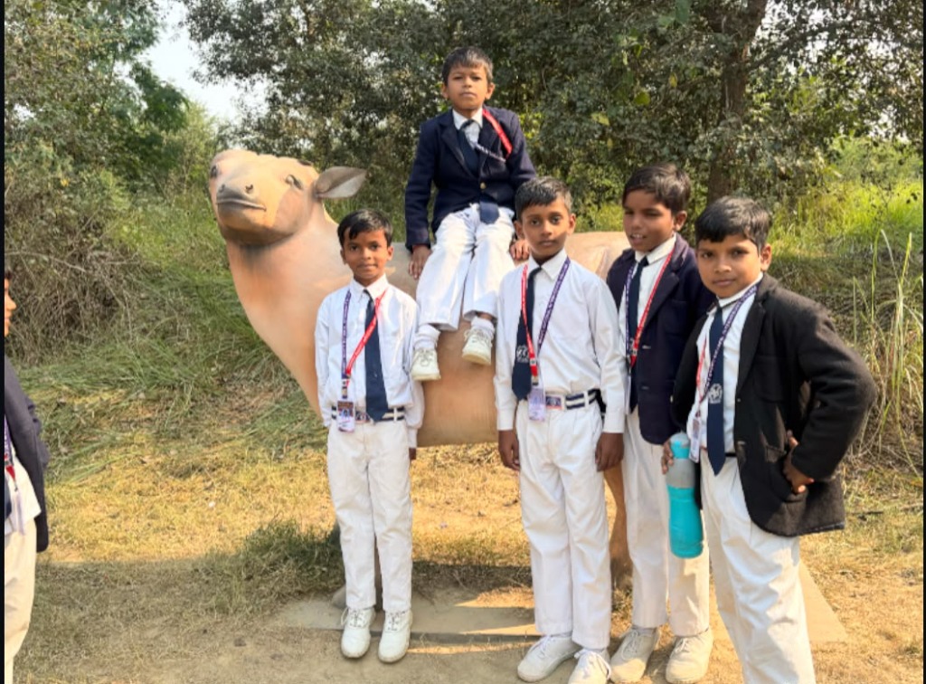 Boys in uniform standing next to a wild bull sculpture