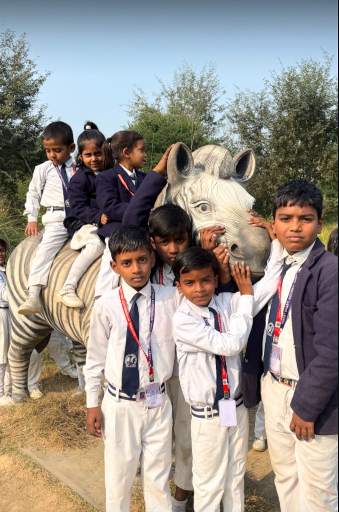 Primary students posing on a zebra sculpture at the zoo